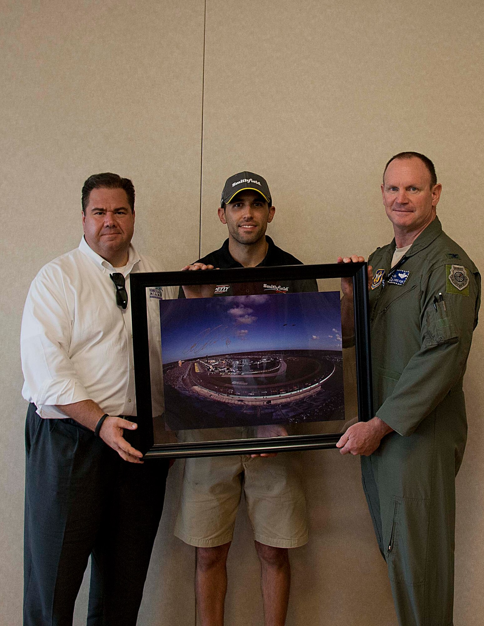 Aric Almirola, driver of the No. 43 Richard Petty Motorsports Ford racecar, and Matt Becherer, president of the Homestead-Miami Speedway, present Col. Chris Funk, 482nd Fighter Wing commander, with a gift during a lunch with Airmen at the Community Activity Center at Homestead Air Reserve Base, Fla., Sept. 10. Almirola visited Homestead ARB before heading to Chicagoland Speedway to participate in the “Chase for the NASCAR Sprint Cup”. (U.S. Air Force photo/Senior Airman Aja Heiden)
