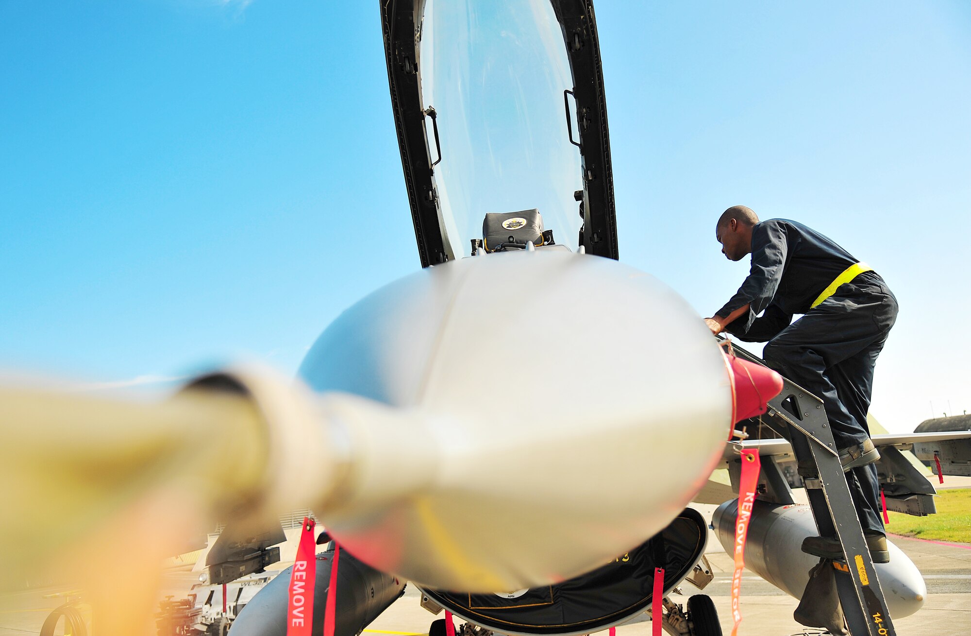 U.S. Air Force Airman 1st Class Jameson Holmes, 35th Aircraft Maintenance Squadron crew chief, climbs onto the cockpit of an F-16 Fighting Falcon during Exercise Beverly Sunrise 14-08 at Misawa Air Base, Japan, Sept. 14, 2014. As part of a pre-flight inspection, crew chiefs check to ensure there are no discrepancies with the aircraft, including inside the cockpit. (U.S. Air Force photo by Senior Airman Jose L. Hernandez-Domitilo/Released)