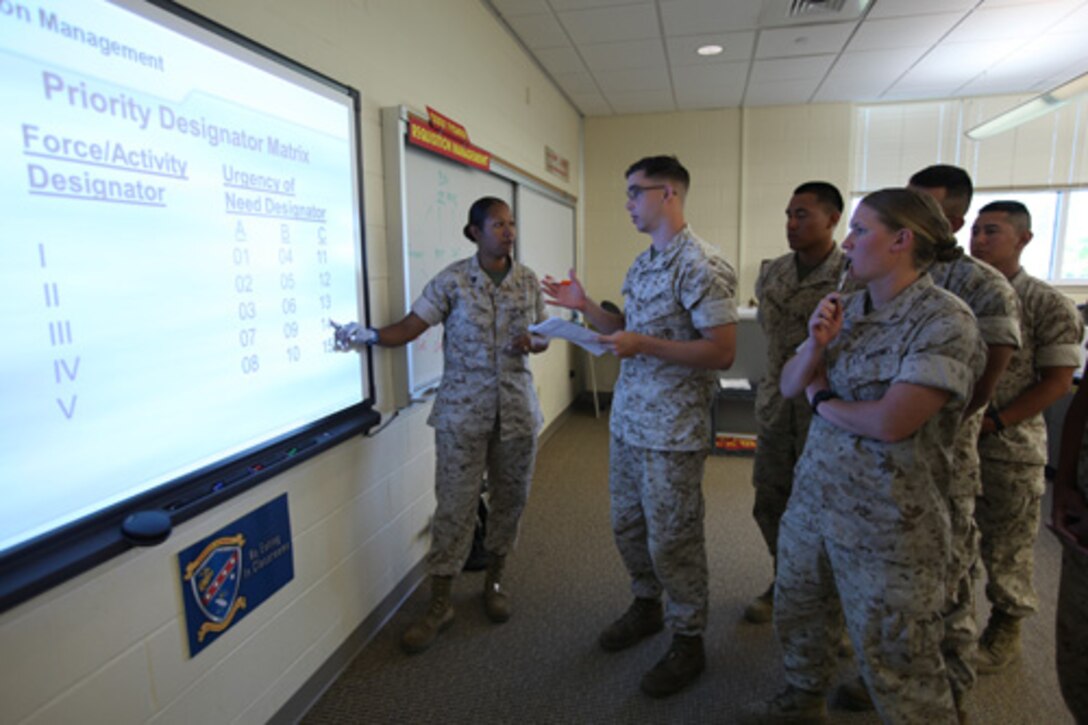 Staff Sergeant Sandra Fisher (far left), Instructor, Enlisted Supply Basic Course 15-14, Ground Supply School (GSS), Marine Corps Combat Service Support Schools, answers some of her Marine students questions for her class held aboard Camp Johnson, N.C. on June 3, 2014. (Combat Camera photo by Lance Corporal Laura Mercado/ Released)