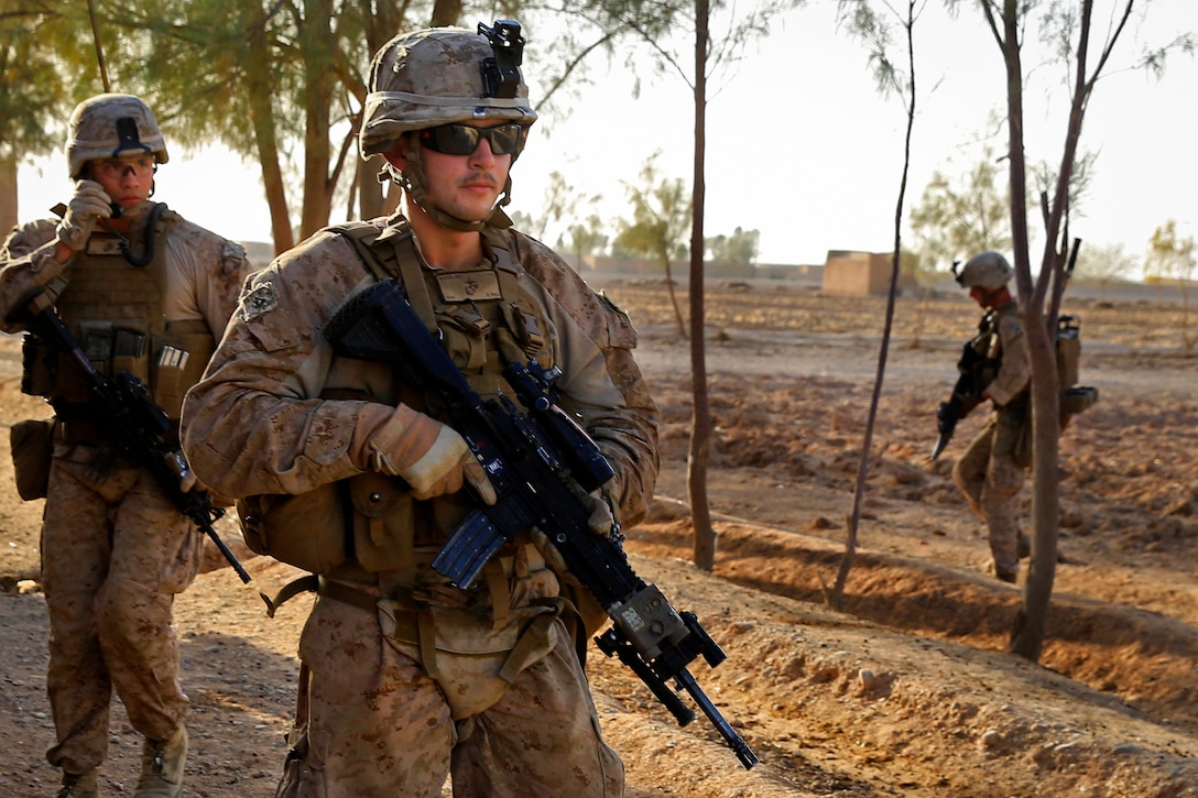 U.S. Marine Corps Lance Cpl. John Buckley, foreground, walks down a ...