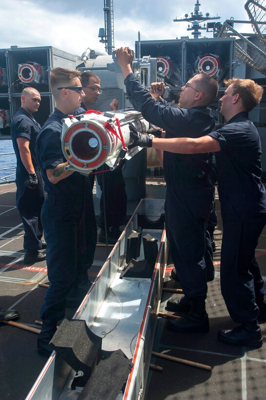 U.S. sailors upload an Evolved Sea Sparrow Missile into a missile launcher aboard aircraft carrier USS Carl Vinson in the Pacific Ocean, Sept. 5, 2014.