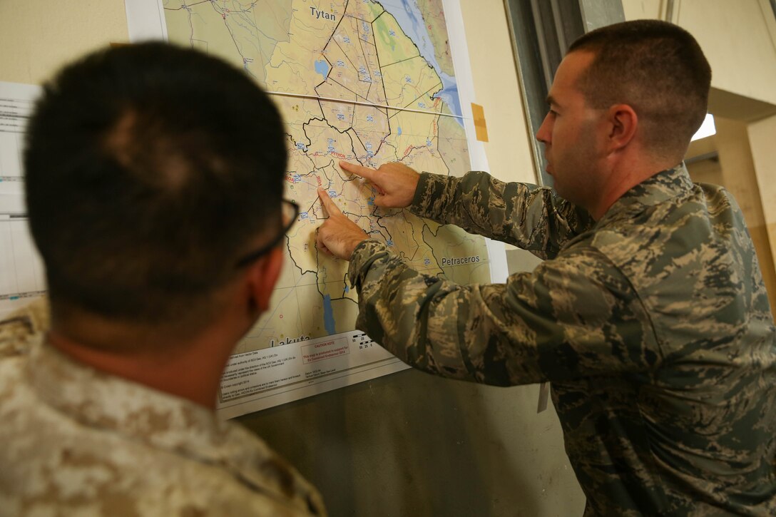 U.S. Air Force Maj. Joshua Garrison and U.S. Marine Sgt. Joseph Gange, cyber analysts with the combined staff 6, responsible for information assurance, network monitoring and system analysis, navigate an area-of-operation map to locate the Land Command Component and Air Command Component during exercise Combined Endeavor 14 in Grafenwhor, Germany, Sept. 9. Combined Endeavor is the world's largest command, control, communication and computer (C4) systems exercise. More than 1,200 communications professionals from 31 NATO and Partnership of Peace countries along with European security partners are participating.