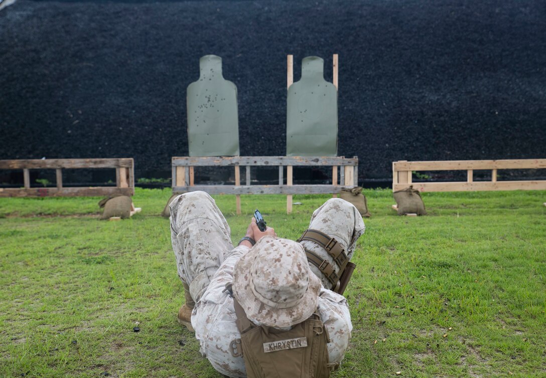 Lance Cpl. Roman Khrystin, from Koveo, Ukraine, fires an M9A1 9 mm service pistol while on his back Aug.26 during combat marksmanship training at Camp Hansen. The training builds on marksmanship skills acquired during annual pistol qualification. Khrystin is a military policeman with Company B, 3rd Law Enforcement Battalion, III Marine Expeditionary Force Headquarters Group, III MEF. (U.S. Marine Corps photo by Lance Cpl. Devon Tindle/Released)