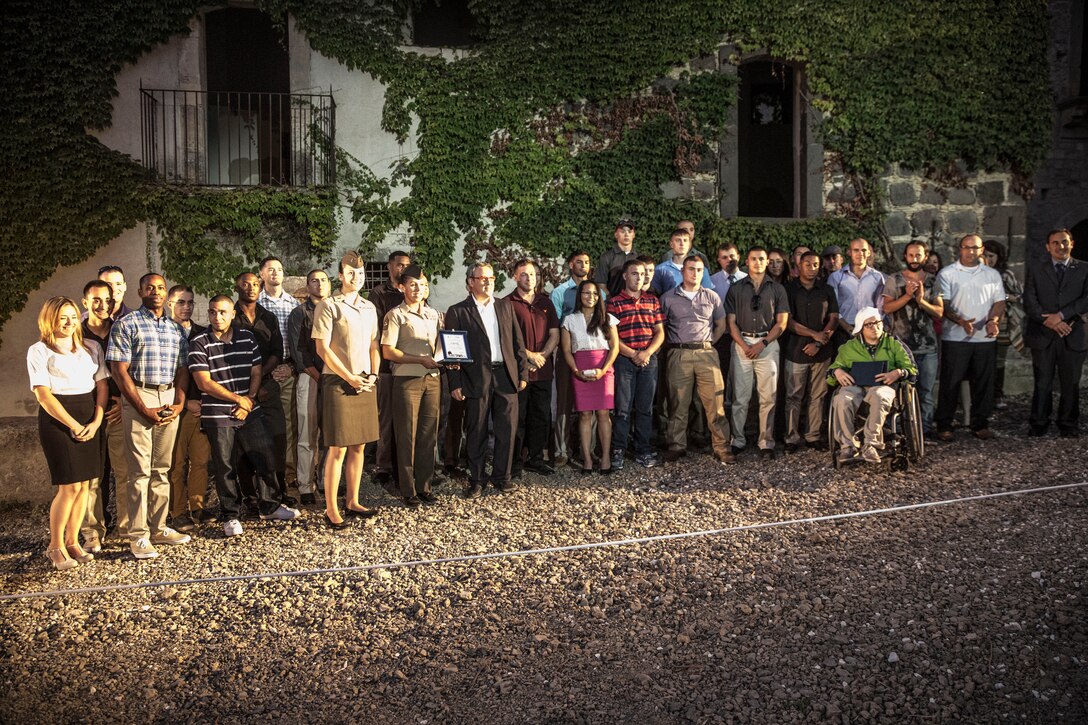 Marines and Sailors with Special-Purpose Marine Air-Ground Task Force Africa 14 pose for a photo with Marco Sinatra, the mayor of Vizzini and Eriberto Muscoso, brother of the event coordinator and director of the “Marines Meet Verga” project, in Cunziria, Vizzini, Sept. 7, 2014. The service members of SP-MAGTF Africa 14 were awarded plaques for the volunteer work they put in to help restore the beauty of Cunziria. After the awards ceremony the Marines and Sailors were privy to a local rendition of Cavalleria Rusticana, or Rustic Chivalry, a drama by famous playwright Giovanni Verga which tells the tale of a soldier who left for war only to return to find his beloved is to be betrothed to another man.