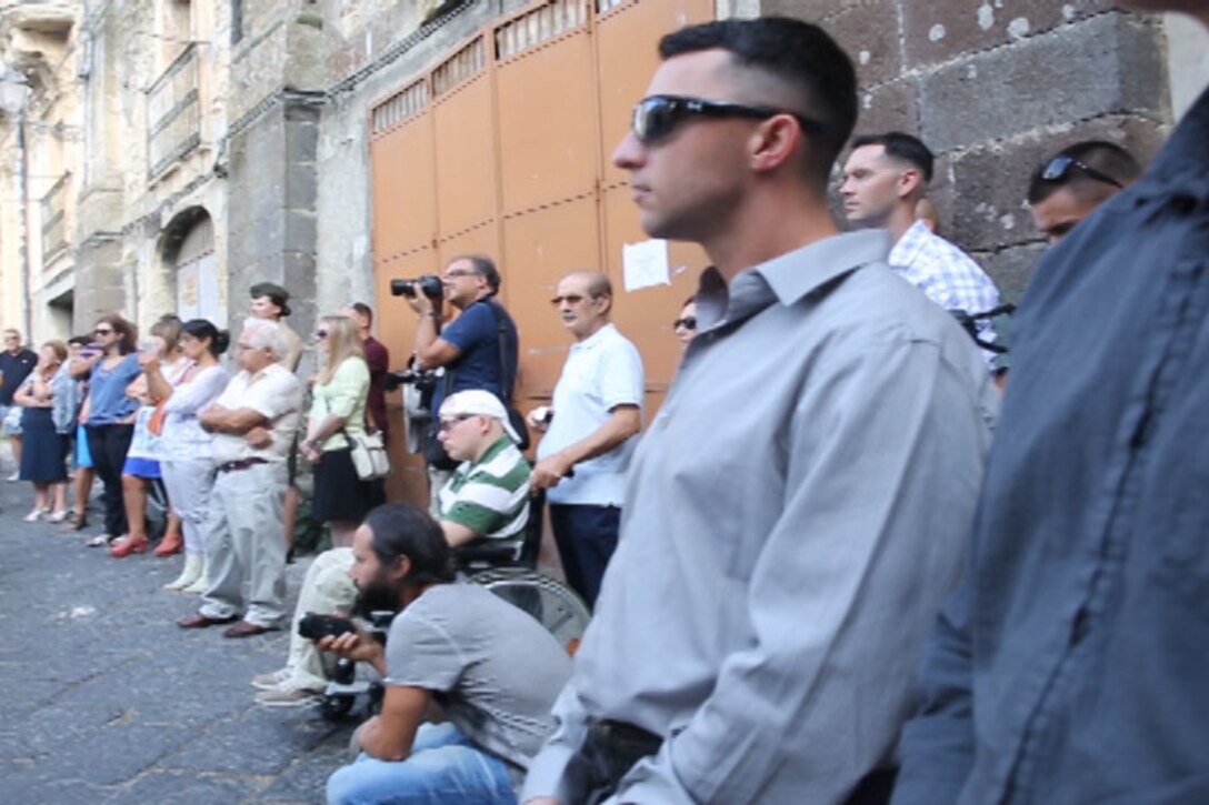 Marines and Sailors with Special-Purpose Marine Air-Ground Task Force Africa 14 stand alongside the Sicilian people enjoying a rendition of Cavalleria Rusticana, or Rustic Chivalry, a drama by famous playwright Giovanni Verga which tells the tale of a soldier who left for war only to return to find his beloved is to be betrothed to another man. The opera was set in the streets of Vizzini, where famous playwright Giovanni Verga was inspired to write the story, Sept. 7, 2014.