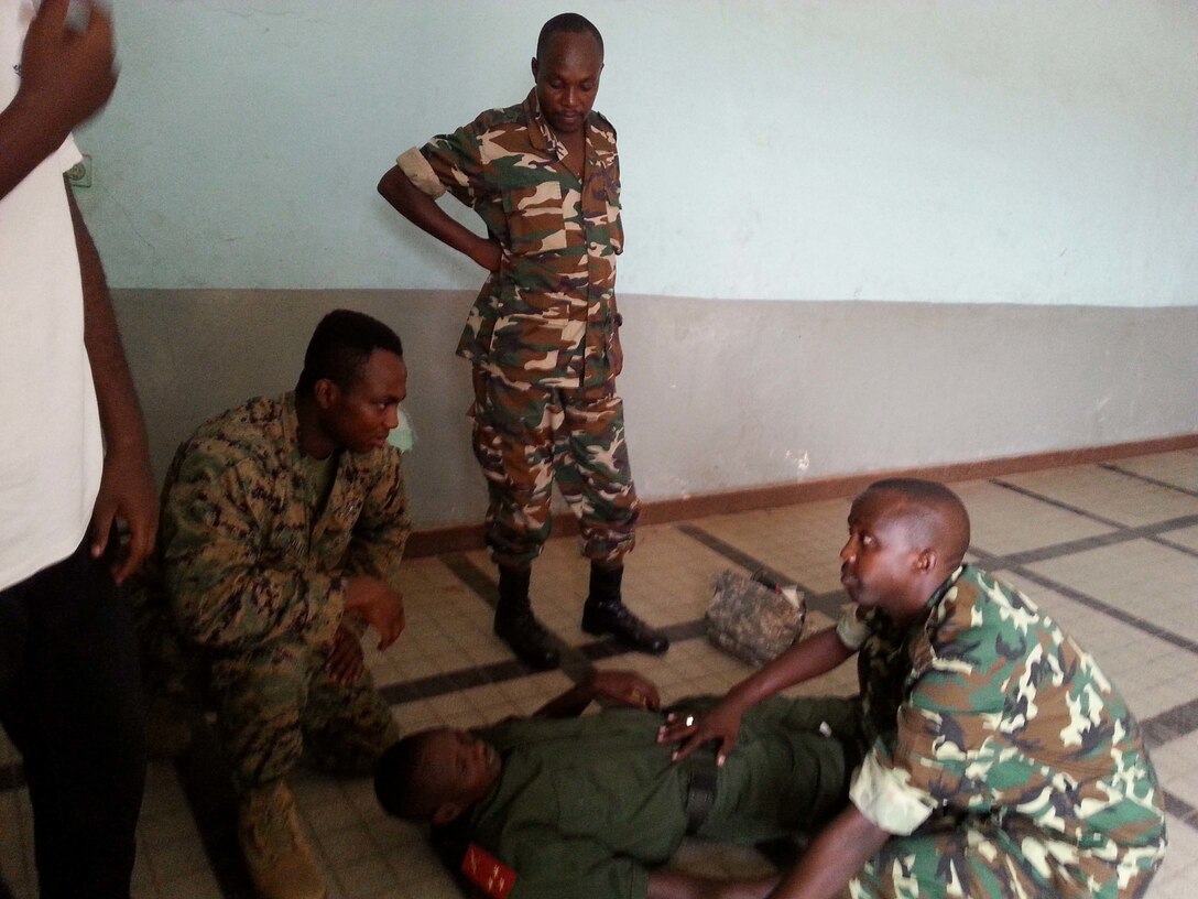 Petty Officer 1st Class Mazamesso Solitoki, a New York, N.Y., native and hospital corpsman with Special-Purpose Marine Air-Ground Task Force Africa 14 and members of the Burundi National Defense Force practice combat-lifesaving procedures in Burundi, Aug. 26, 2014, during  a tactical advising course with the Burundi National Defense Forces. Topics covered included maintenance management planning, counter improvised explosive device, general engineering, troop leading steps, orders development, combat lifesaving and trauma care, and convoy planning. SP-MAGTF Africa conduct theater security cooperation and military-to-military engagements while providing U.S. Africa Command a rapid-response capability in North and West Africa.  (Courtesy Photo)