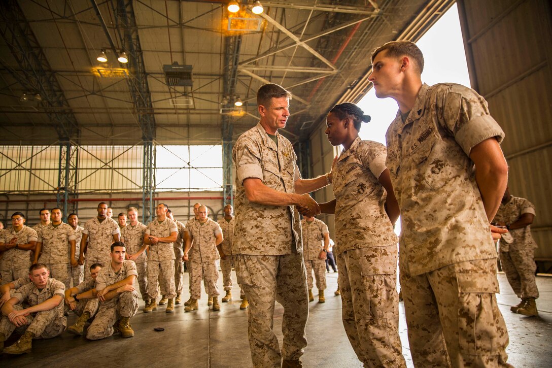 Maj. Gen. William D. Beydler (left), the commanding general of II Marine Expeditionary Force and U.S. Marine Corps Forces Africa, shakes hands with Cpl. Tirrany James (center), a New Orleans, La., native and fiscal clerk with SP-MAGTF Africa 14, aboard Naval Air Station Sigonella Sept. 13, 2014. Cpl. Tirrany James and Cpl. Kevin Peach, a Port St. Lucie, Fla., native and rifleman with SP-MAGTF Africa 14, were recognized during the visit for their performance on deployment. (U.S. Marine Corps photo by Cpl. Shawn Valosin)