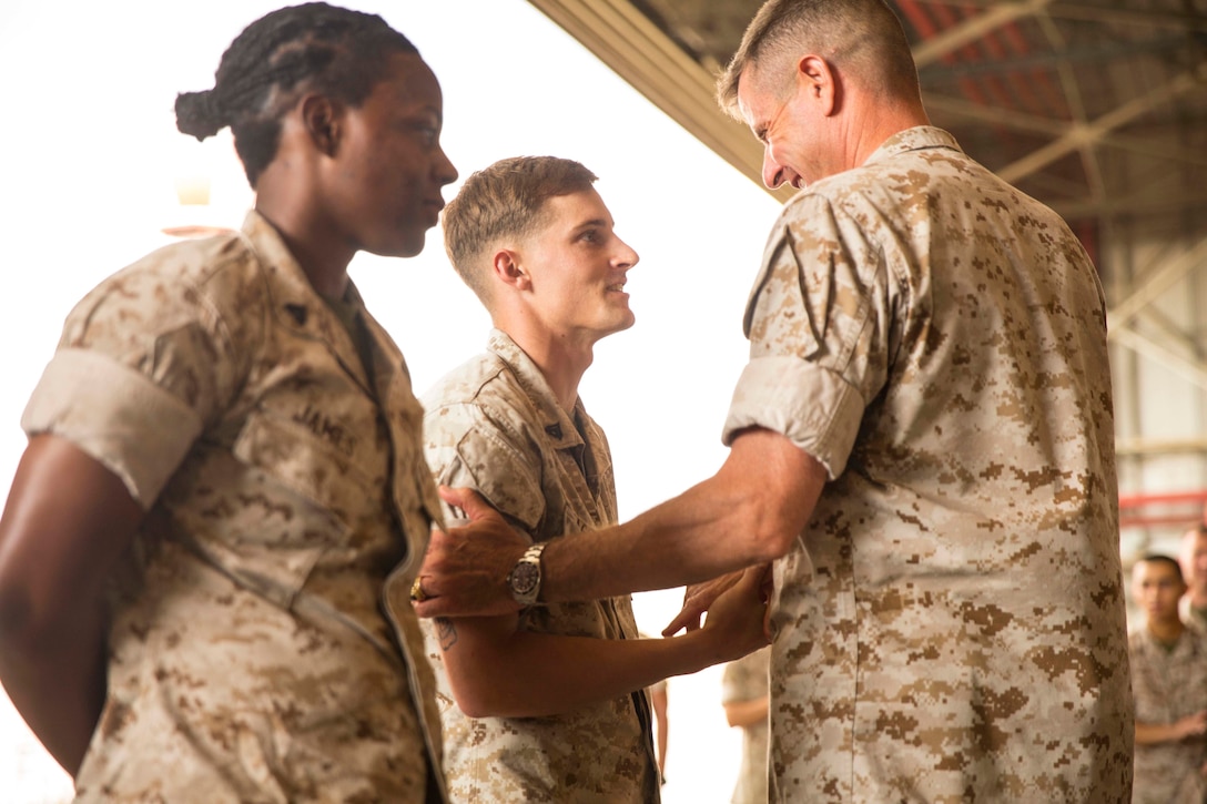 Maj. Gen. William D. Beydler (right), the commanding general of II Marine Expeditionary Force and U.S. Marine Corps Forces Africa, shakes hands with Cpl. Kevin Peach (center), a Port St. Lucie, Fla., native and rifleman with SP-MAGTF Africa 14, aboard Naval Air Station Sigonella Sept. 13, 2014. Cpl. Kevin Peach and Cpl. Tirrany James, a New Orleans, La., native and fiscal clerk with SP-MAGTF Africa 14, were recognized during the visit for their performance on deployment. (U.S. Marine Corps photo by Cpl. Shawn Valosin)