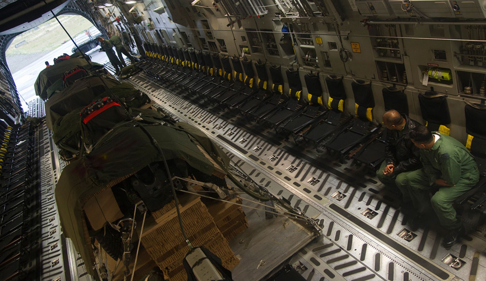 Indian air force Wing Cmdrs. Sukumar S. Kumar and Anil Vesma, discuss the aerial procedures of the 517th Airlift Squadron prior to an air drop mission Sept. 9, 2014, at Joint Base Elmnedorf-Richardson, Alaska. Indian air force personnel were visiting Elmendorf as part of a tactics, techniques and procedures exchange program between the two countries. It marked the first time such training has been conducted between India and the U.S. Air Force at Elmendorf. (U.S. Air Force photo/Staff Sgt. Sheila deVera)