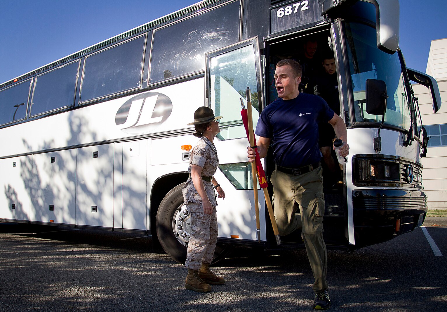Sgt. Tiffany Nielsen-Nowakowski, a drill instructor with 4th Recruit Training Battalion, Marine Corps Recruit Depot Parris Island, S.C., motivates Philip Samoylovich, a poolee from Recruiting Substation Burlington, to exit a bus during Recruiting Station Seattle’s annual west side pool function at Foster High School in Tukwila, Wash., Sept. 13, 2014. During the event, Washington-based recruiters teamed with drill instructors to physically and mentally prepare enlistees for boot camp. The enlistees, part of the Marine Corps delayed entry program, are awaiting their ship dates. Nielsen-Nowakowski, 26, is from Ferris, Texas. Samoylovich, 20, is from Bellingham, Wash., and attended Ferndale High School in Ferndale, Wash. He was recruited by Sgt. Justin McKelvey and lost 116 lbs. to enlist in the Marine Corps. (U.S. Marine Corps photo by Sgt. Reece Lodder)