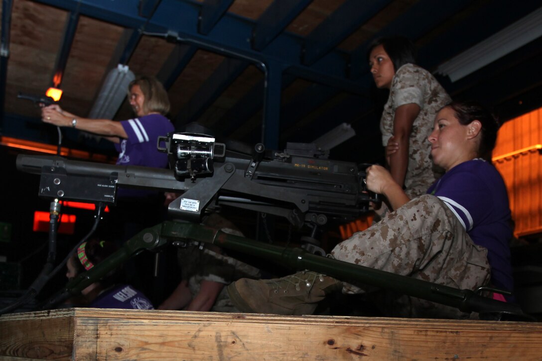 Kimberly A. Alaniz fires a MK-19 automatic grenade launcher inside an Indoor Simulated Marksmanship Trainer during a Jane Wayne Day hosted by Marine Wing Headquarters Squadron 2 at Marine Corps Air Station Cherry Point, N.C., Sept. 12, 2014.
Alaniz, a former Sailor, is a stay at home mom, soccer coach and wife of Staff Sgt. Israel G. Alaniz, an aviation supply specialist with MWHS-2. Both are natives of Port Isabel, Texas. 
During the event, spouses and other extended MWHS-2 family members toured portions of the air station to learn more about the day-to-day lives of their Marines. The day included familiarization classes with Marine Corps weapon systems at the ISMT; aircraft simulators; and a demonstration of the Marine Corps Martial Arts Program.
