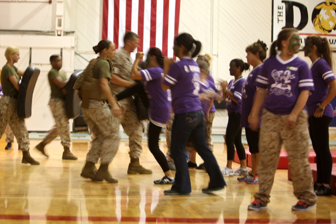 Spouses and family members with Marine Wing Headquarters Squadron 2 perform defensive strikes as part of a Marine Corps Martial Arts demonstration during a Jane Wayne Day hosted by Marine Wing Headquarters Squadron 2 at Marine Corps Air Station Cherry Point, N.C., Sept. 12, 2014. 
During the event, spouses and other extended MWHS-2 family toured portions of the air station to learn more about the day-to-day lives of their Marines. The day included familiarization classes with Marine Corps weapon systems at an Indoor Simulated Marksmanship Trainer; aircraft simulators; and a MCMAP demonstration.