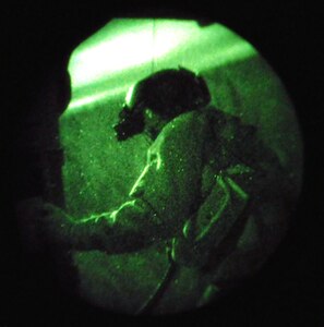 A flight engineer with the 210th Rescue Squadron prepares for a simulated hoist extraction during a nighttime training flight on an HH-60G Pavehawk Nov. 5, 2009. Kulis Air National Guard rescue squadrons conduct training missions five days a week around the Alaska airspace. Most rescue training operations occur during the nighttime hours which help Guardsmen become more efficient and increase survivability in combat.