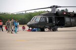 Airmen from the Kentucky National Guard's 123rd Contingency Response Group help offload wounded Haitian refugees and medical personnel from Puerto Rico National Guard UH-60 Blackhawk helicopters at the air hub in Barahona, Dominican Republic, Jan. 25, 2010.