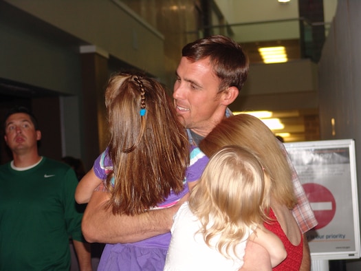 Staff Sgt. Michael Edwards' family welcomes him home from deployment Sept. 14. Edwards and fellow teammates Tech Sgt. Joseph Burke and Senior Airman Joshua Frehner were the last explosive ordnance disposal team to support combat commanders in Afghanistan. (U.S. Air Force Photo/Lois Walsh) 
