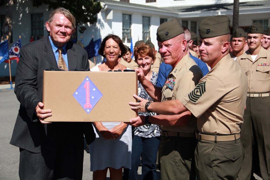 The commanding general of the 1st Marine Division, Maj. Gen. Larry D. Nicholson, accepts a final donation of socks from Jim and Carla Hogan during a ceremony here, Sept. 12. Their son, Lance Cpl. Donald Hogan, was posthumously awarded the Navy Cross for heroic action in 2009 while serving with 1st Battalion, 5th Marine Regiment, 1st Marine Division in Nawa, Afghanistan. The Hogans, from San Clemente, Calif., founded Socks for Heroes following the death of their son in Afghanistan in 2009, as a way to improve the lives of service members deployed in austere environments. Since May 2011, the organization has sent over 330,000 socks to Marines and soldiers in Afghanistan.