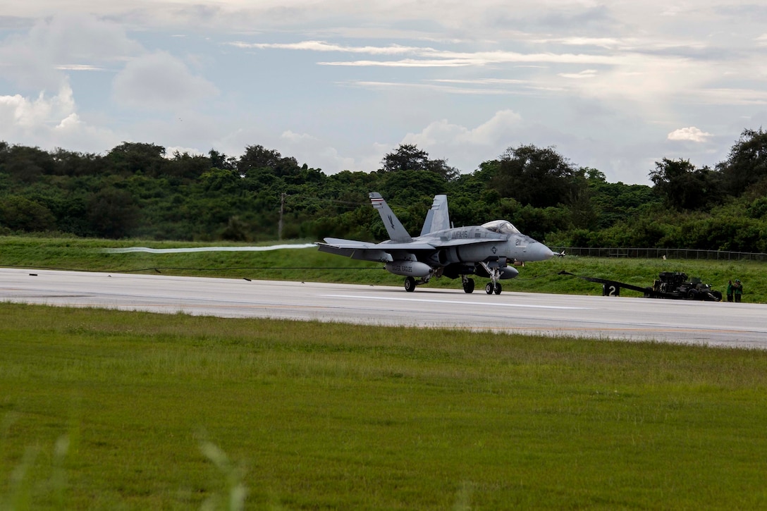 An FA-18C Hornet makes an arrested landing using the M31 Marine Corps Expeditionary Arresting Gear System Sept. 15 at Tinian's West Field during Exercise Valiant Shield 2014. Arresting gear is used in order to land pilots in a short amount of space, or during an emergency. Valiant Shield is a biennial exercise which focuses on training that enables real-world proficiency in sustaining joint forces. The Hornet is with Marine Fighter Attack Squadron 115, currently assigned to Marine Aircraft Group 12, 1st Marine Aircraft Wing, III Marine Expeditionary Force. (U.S. Marine Corps photo by Cpl. David A. Walters/Released)