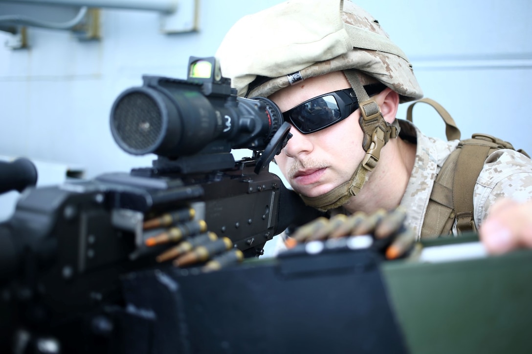 Lance Cpl. Colton Welker, a machine gunner with Golf Company, Battalion Landing Team 2nd Battalion, 1st Marines, 11th Marine Expeditionary Unit, searches for potential threats as part of small craft action team drill aboard the USS Makin Island (LHD 8), Sept. 15. The 11th MEU is deployed with the Makin Island Amphibious Ready Group as a theater reserve and crisis response force throughout U.S. Central Command and the U.S 5th fleet area of responsibility. (U.S. Marine Corps photo by Lance Cpl. Evan R. White/ RELEASED)