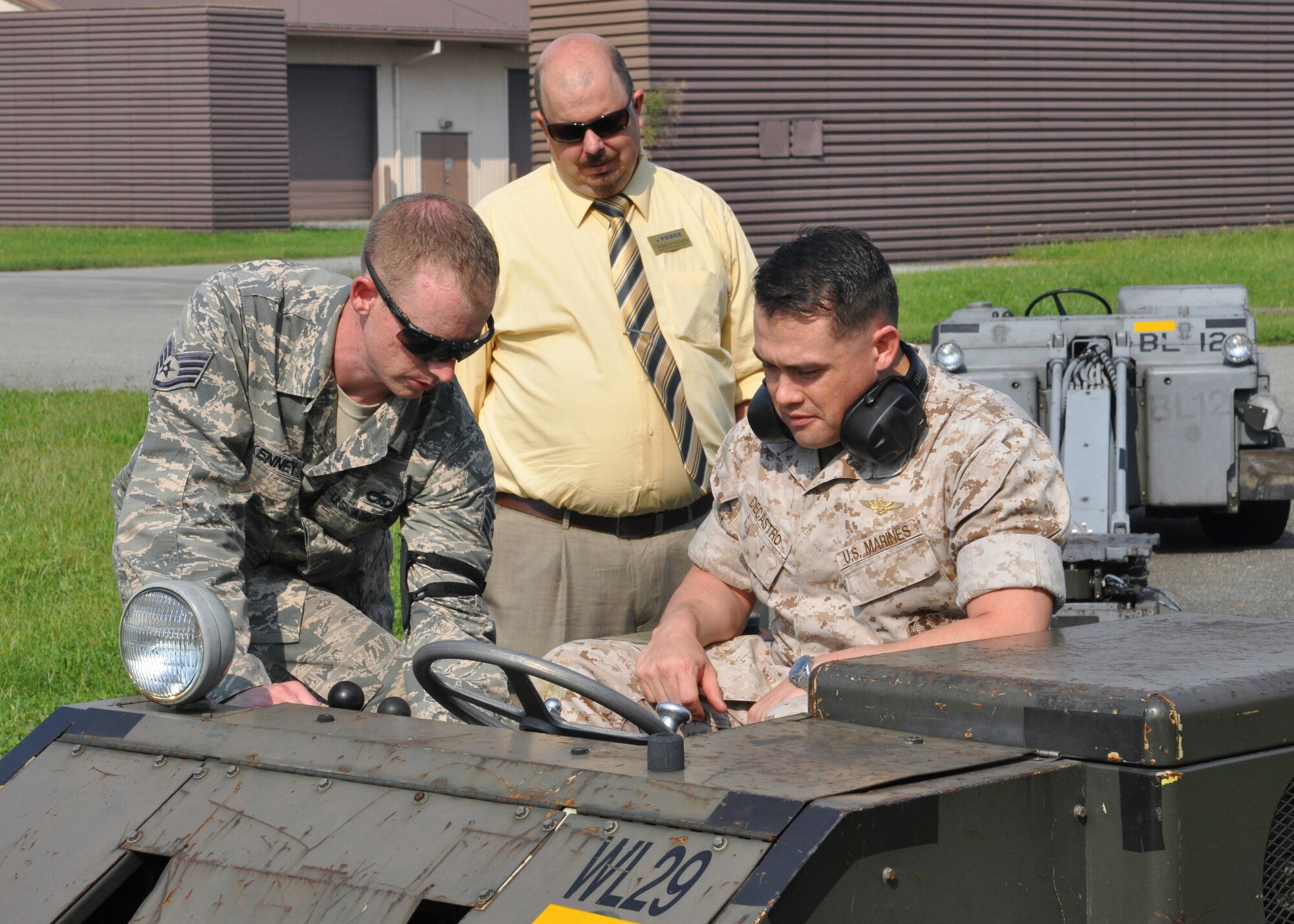 Staff Sgt. Brandon McKenney, 51st Maintenance Squadron aerospace group equipment craftsman, shows U.S. Marine Maj. Bryon DeCastro, 7th AF Marine liaison, and Mr. Anthony Chatfield, 51st Force Support Squadron deputy director, how to operate a MJ-1 weapons loader, at Osan Air Base, Republic of Korea, Sept. 8, 2014.  Leadership from across Team Osan participated in the annual Mustang Immersion to develop a better understanding of what Osan Airmen are able to bring to the fight.  (U.S. Air Force photo/Capt. Robert Howard)