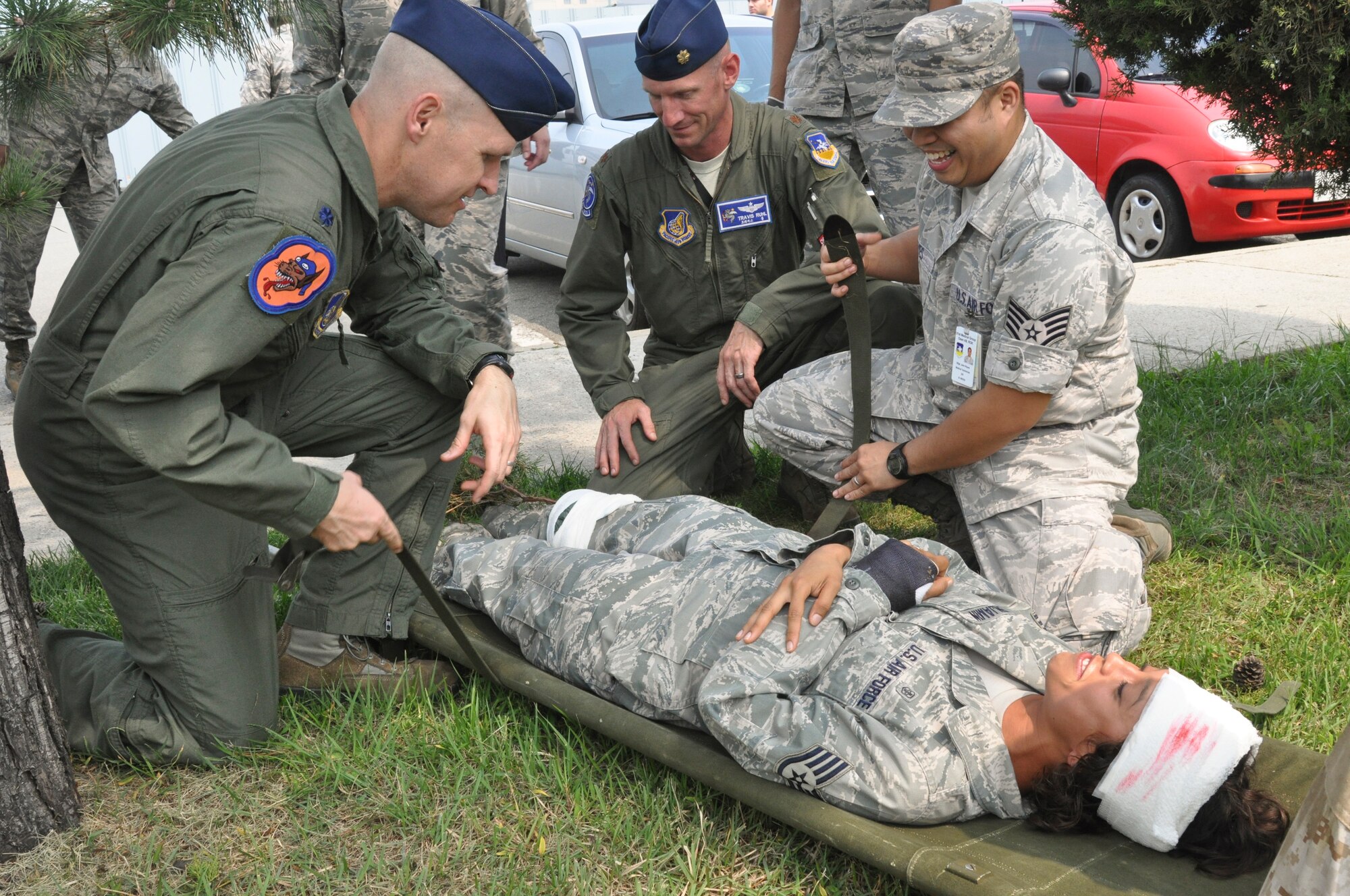 Lt. Col. Nicholas Evans, 36th Fighter Squadron commander, and Maj. Travis Ruhl, 51st Operations Support Squadron director of operations, attempt to secure a simulated patient with help from Staff Sgt. John Reyes, 51st Medical Group medical statistics technician, at Osan Air Base, Republic of Korea, Sept. 8, 2014.  Leadership from across Team Osan participated in the annual Mustang Immersion to develop a better understanding of what Osan Airmen are able to bring to the fight.  (U.S. Air Force photo/Capt. Robert Howard)