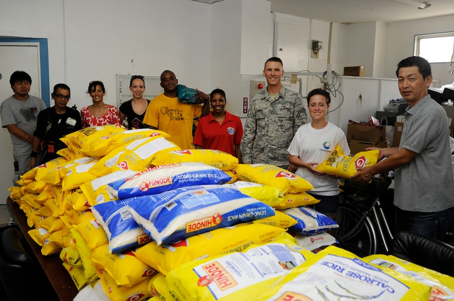 U.S. Air Force Airmen with Operation Rice Run and workers from Bethania Church pose in front of more than 3,400 pounds of rice that was delivered to feed the homeless in Naha City, Japan, Sept. 12, 2014. This program was created last year by Staff Sgt. John Kaczmar, Det. 3 Pacific Air Force Air Postal Squadron military postal supervisor, when he and his friends donated fish to the church and found out what they really needed was rice. (U.S. Air Force photo by Senior Airman Marcus Morris/Released)
