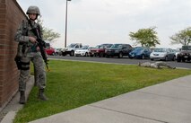 A 92nd Security Forces Squadron Airman takes cover during an active shooter exercise at the Survival, Evasion, Resistance and Escape dorms at Fairchild Air Force Base, Washington, Sept. 16, 2014. The exercise was to prepare the Airman for real life situations where an active shooter could pose a threat.  (U.S. Air Force photo by Airman 1st Class Taylor Bourgeous/Released)