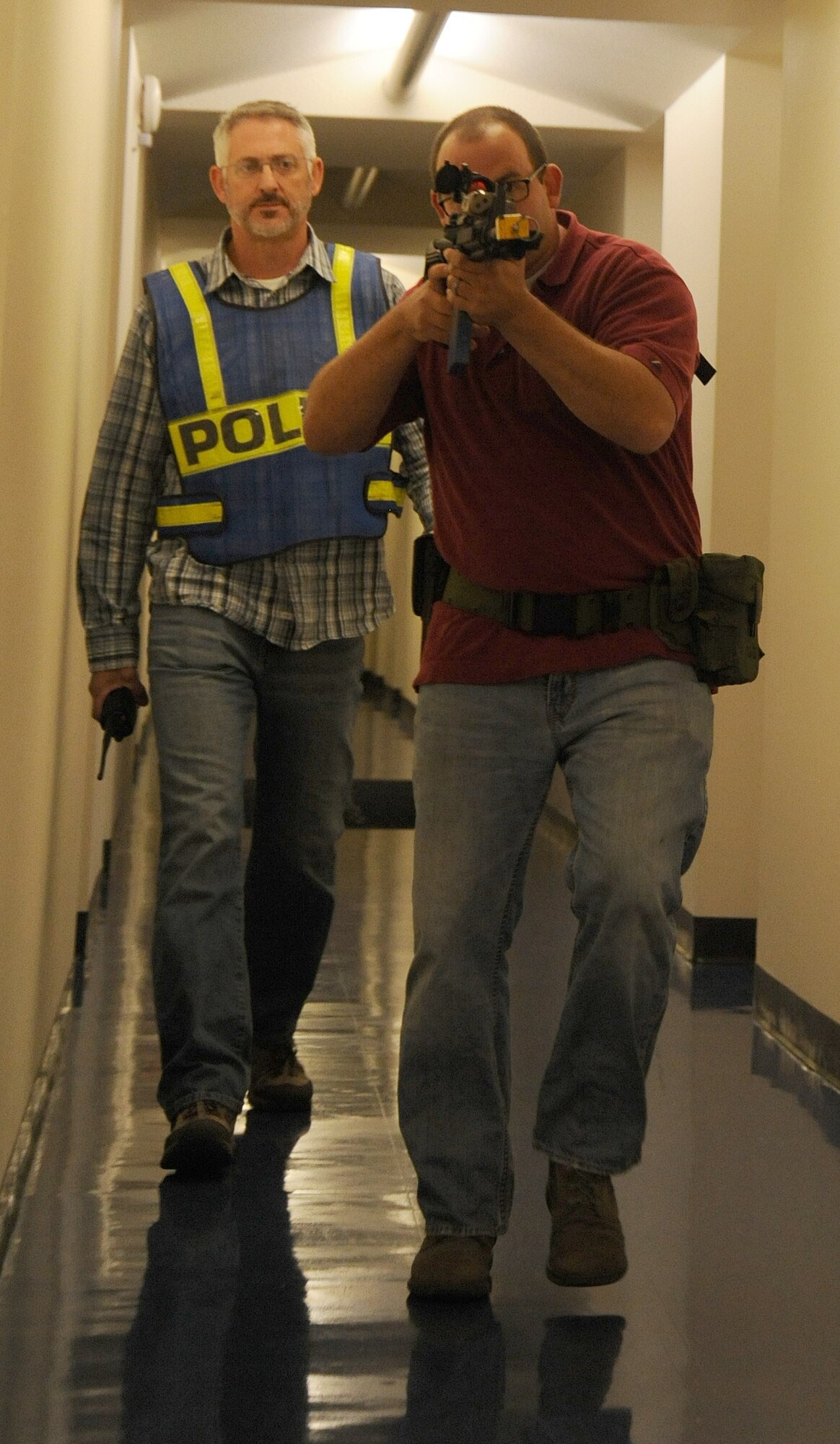 Tech Sgt. Derek Washburn, 92nd Security Forces flight sergeant, and J. Colt, 92nd SFS trainer, participates in an active shooter exercise at Fairchild Air Force Base, Washington, Sept. 16, 2014. The exercise occurred in the Survival Evasion Resistance and Escape dorms to help prepare students for what to do in the event a shooting takes place within the confines of the base. (U.S. Air Force photo by Staff Sgt. Samantha Krolikowski/Released)