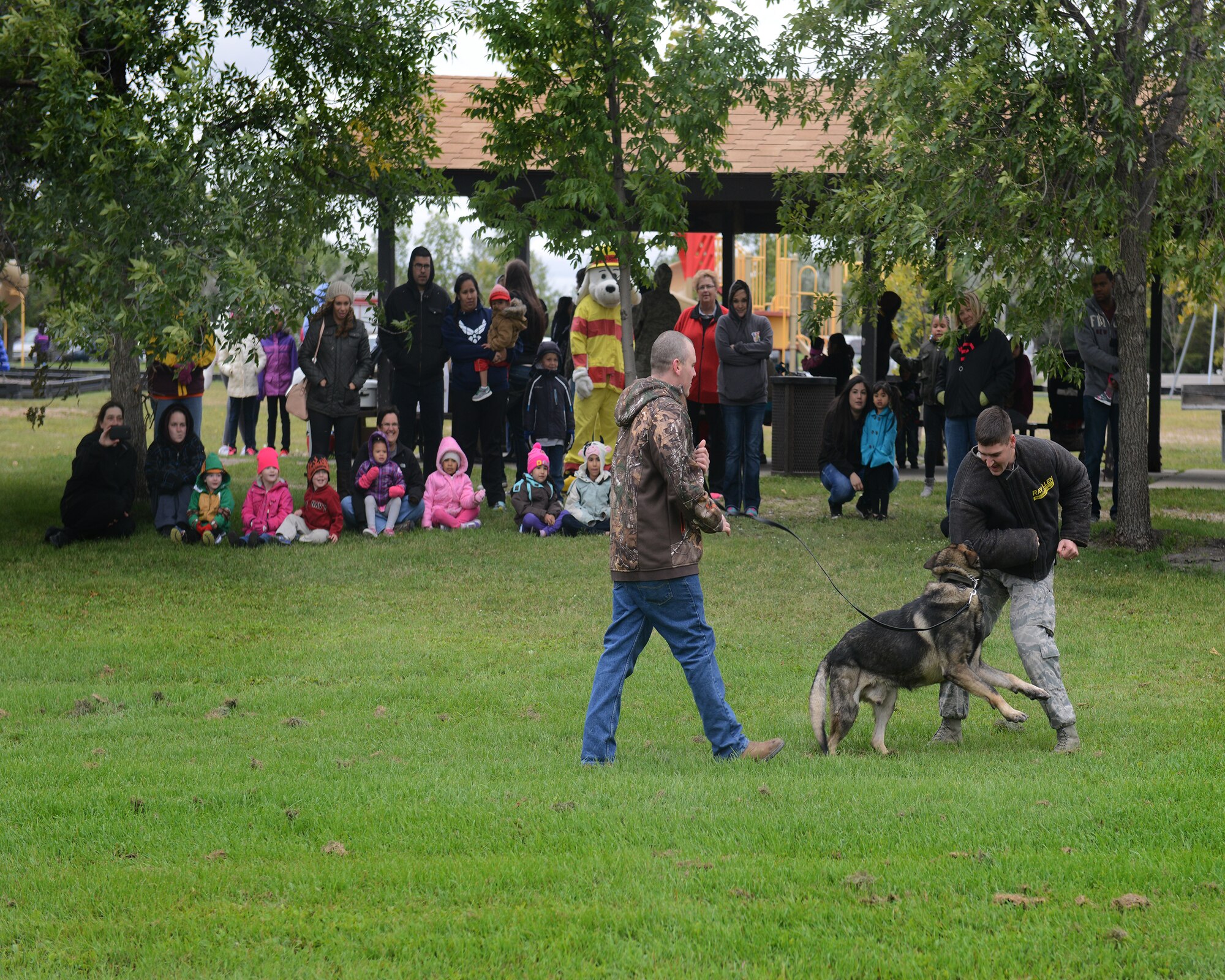 Children enrolled in the Head Start program watch a K-9 demonstration with their families on Minot Air Force Base, N.D., Sept. 10, 2014.  The demonstration was accompanied by a fire truck and Humvee display, as well as a barbeque picnic. The program is designed to create opportunities for children at a young age.  (U.S. Air Force photo/Airman 1st Class Lauren Pitts)  