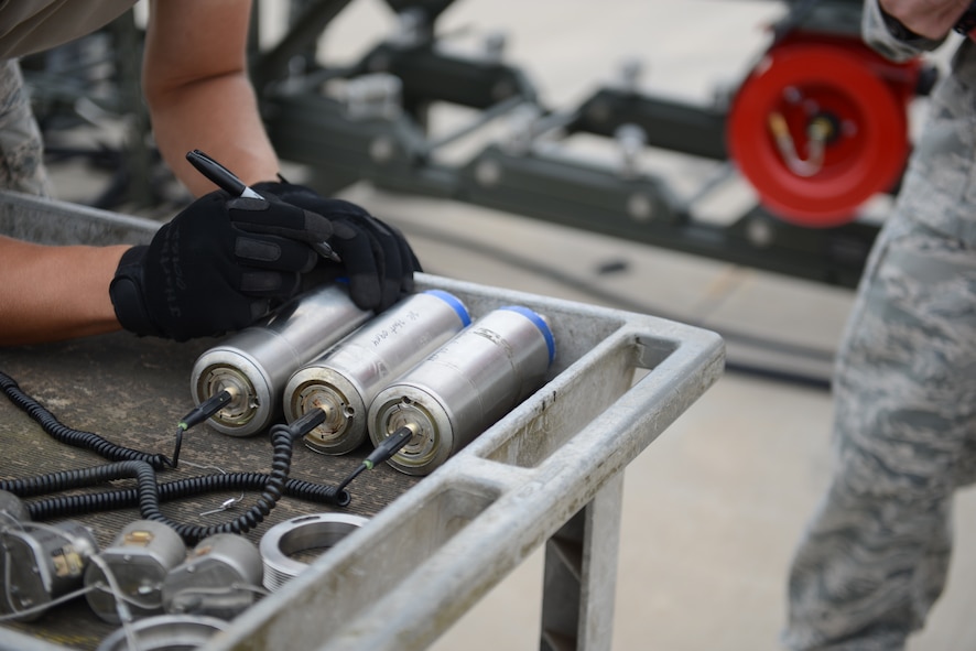 U.S. Air Force Airman 1st Class Jeremiah Hartbarger, 7th Munitions Squadron conventional maintenance crewmember, marks the service life on bomb fuses that will be used to assemble inert bombs during the Global Strike Challenge Sept. 11, 2014, at Dyess Air Force Base, Texas. The Global Strike Challenge identifies the best operations, maintenance, security forces personnel and units performing the Air Force global strike mission throughout the competition. (U.S. Air Force photo by Airman 1st Class Kedesha Pennant/Released)