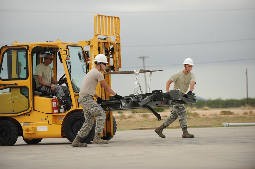 Airmen from the 7th Munitions Squadron use a forklift to move parts of a munitions assembly conveyer as part of the Global Strike Challenge Sept. 11, 2014, at Dyess Air Force Base, Texas. Airmen who participated in the events were chosen according to their leaders’ and supervisors’ recommendations. (U.S. Air Force photo by 2nd Lt. Lauren Linscott/Released)