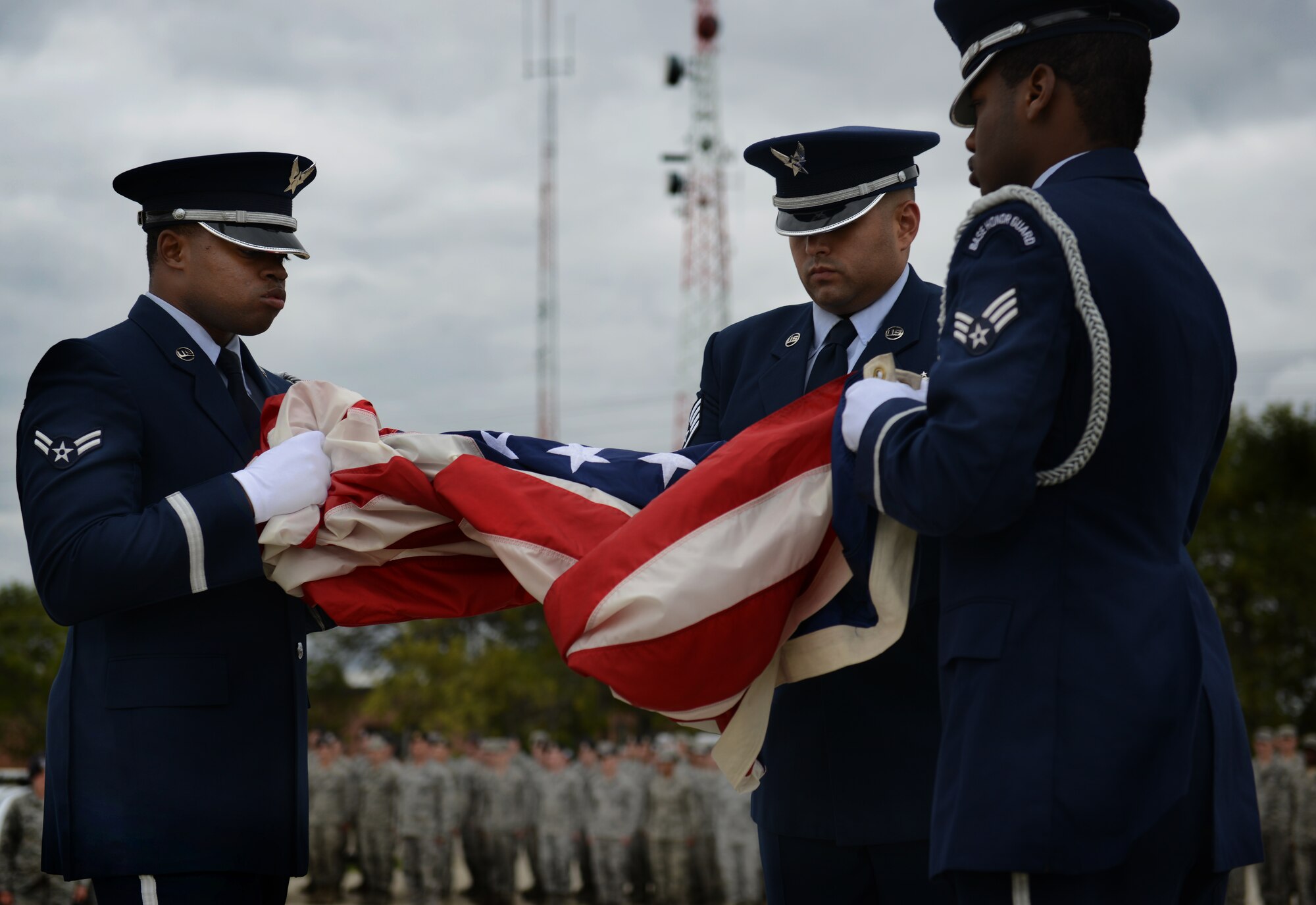 Members of the Minot Air Force Base Honor Guard begin to fold the flag during the Sept. 11 memorial ceremony on Minot Air Force Base, N.D. The ceremony was meant to commemorate those lost in the terrorist attacks in 2001. (U.S. Air Force photos/Airman 1st Class Lauren Pitts)     140911-F-CW009-003