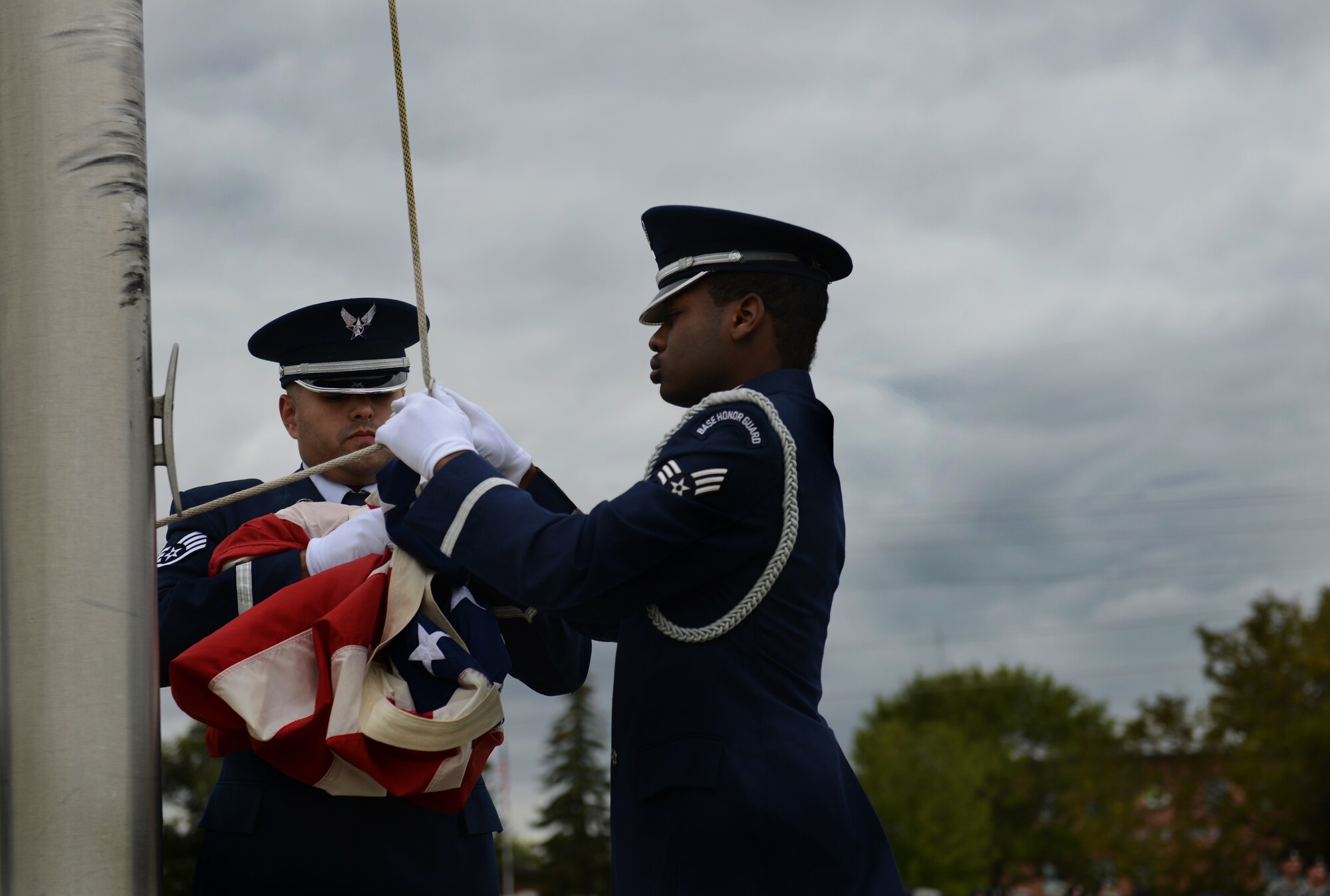 Members of the Minot Air Force Base Honor Guard unhook the flag before folding it during the Sept. 11 memorial ceremony on Minot AFB, N.D.The ceremony was meant to pay tribute to those who lost their lives in the 2001 terrorist attacks. (U.S. Air Force photos/Airman 1st Class Lauren Pitts) 