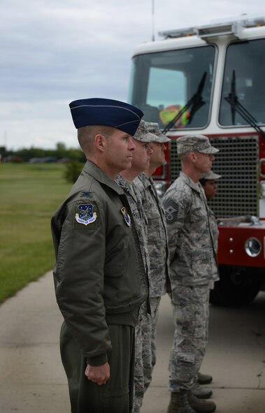 Col. Mike Lutton, 91st Missile Wing commander, looks on as the Minot Air Force Base Honor Guard performs a flag folding ceremony during the Sept. 11 memorial retreat on Minot AFB, N.D. The ceremony included a moment of silence to remember those who perished in the attacks in 2001. (U.S. Air Force photos/Airman 1st Class Lauren Pitts)