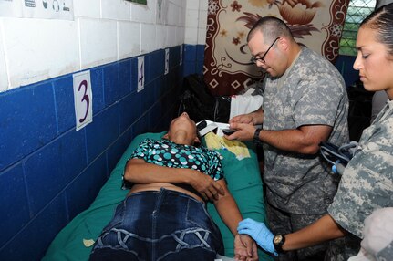 U.S. Army Sgts. Gary Aaron and Dionna Ferrell treat a woman who passed out due to an asthma attack and pneumonia. JTF-Bravo's Medical Element, in conjunction with the 1-228th Aviation Regiment, U.S. Embassy in San Salvador, the El Salvador Ministry of Health and El Salvador military, conducted a medical readiness training exercise (MEDRETE) in La Poza, Department of Usulután, El Salvador, September 8-11 where over 1,250 people received medical care. (Photo by U.S. Air National Guard Capt. Steven Stubbs)