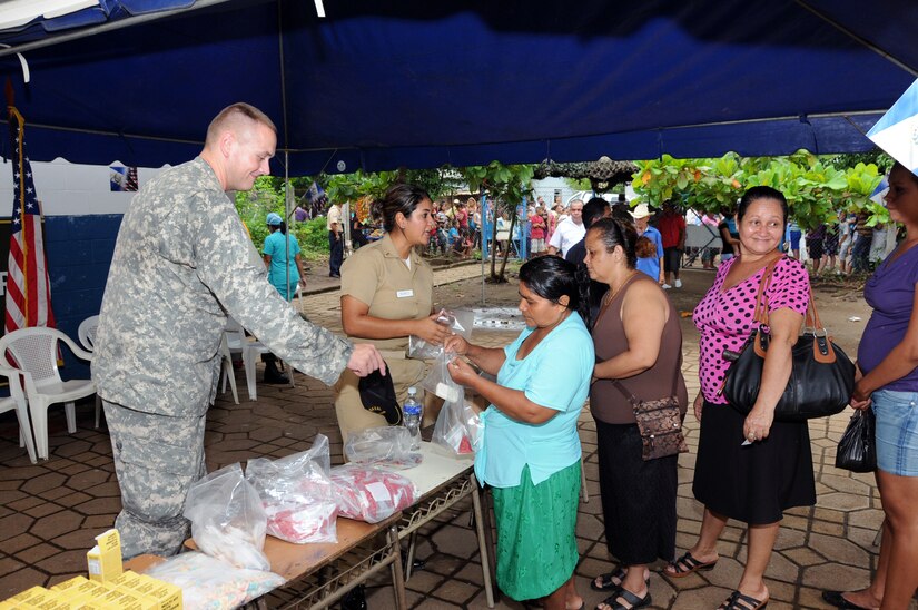 U.S. Army Spc. Tommy Gunn, a MEDEL preventative medicine technician, and an El Salvador Navy service member hand out vitamins and soap to the population of La Poza, El Salvador. JTF-Bravo's Medical Element, in conjunction with the 1-228th Aviation Regiment, U.S. Embassy in San Salvador, the El Salvador Ministry of Health and El Salvador military, conducted a medical readiness training exercise (MEDRETE) in La Poza, Department of Usulután, El Salvador, September 8-11 where over 1,250 people received medical care. (Photo by U.S. Air National Guard Capt. Steven Stubbs)