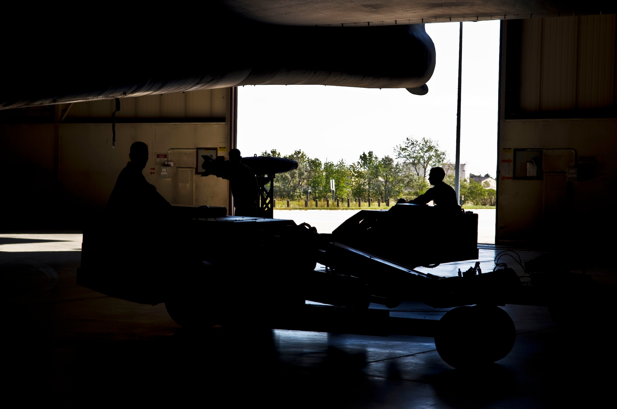A weapons load crew team from the 5th Aircraft Maintenance Squadron, loads a joint direct attack GBU-38 munition from a trailer onto a MJ-1 Jammer on Minot Air Force Base, N.D., Sept. 5, 2014. The load crew is evaluated on how quickly they load munitions on a B-52H Stratofortress and how many discrepancies are found. (U.S. Air Force photo/Senior Airman Brittany Y. Bateman)