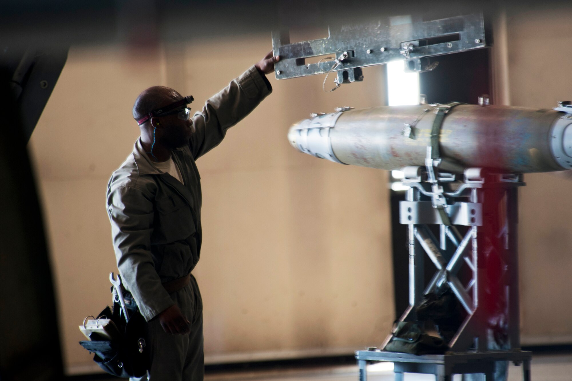 Staff Sgt. Kelvin McCrea, 5th Aircraft Maintenance Squadron weapons load crew member, loads a joint direct attack GBU-38 munition from a trailer onto a MJ-1 Jammer on Minot Air Force Base, N.D., Sept. 5, 2014. McCrea is a part of the weapons load crew competing in the 2014 Global Strike Challenge. (U.S. Air Force photo/Senior Airman Brittany Y. Bateman)