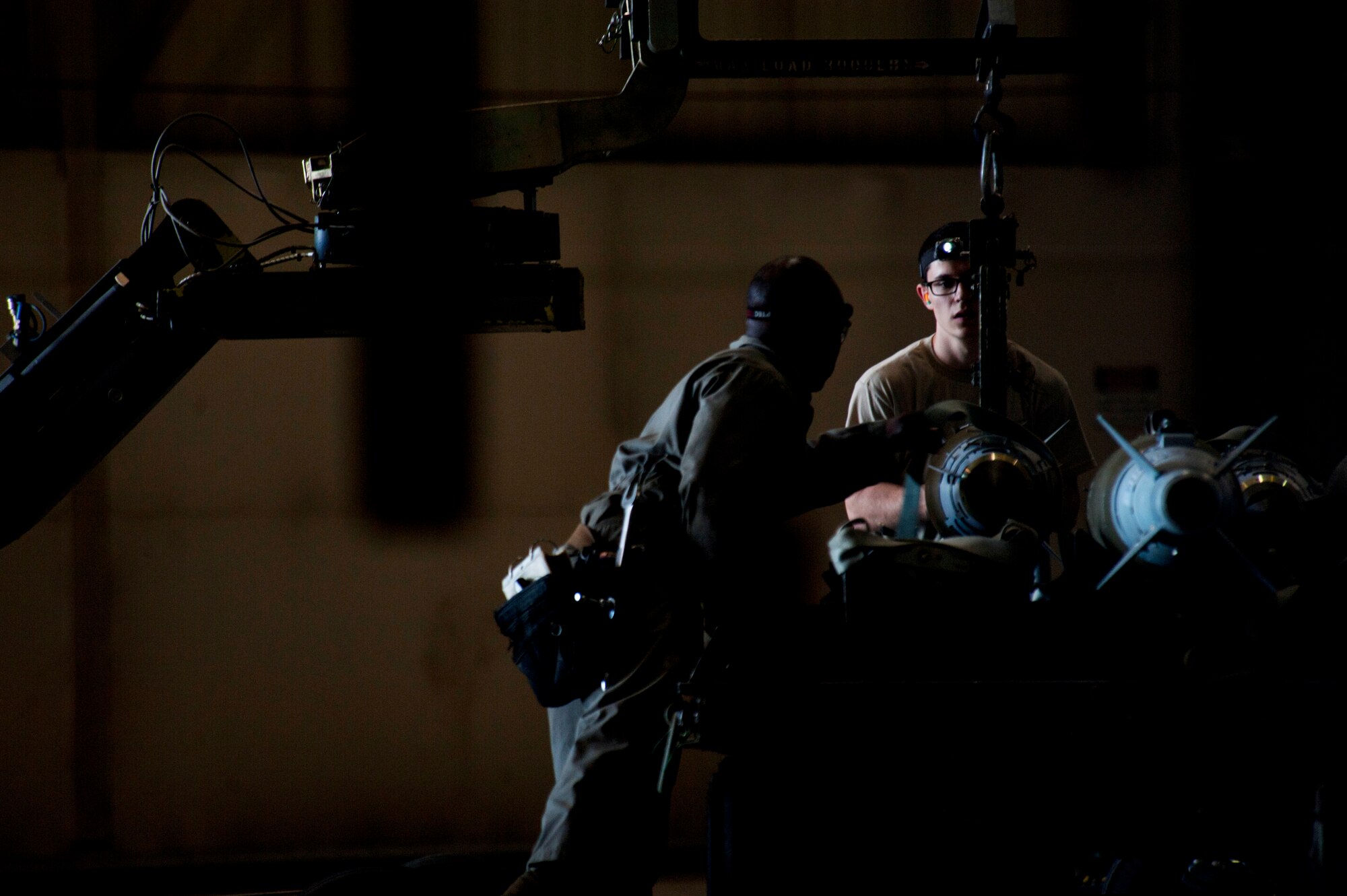 Staff Sgt. Kelvin McCrea and Senior Airman Andrew Grimes, 5th Aircraft Maintenance Squadron weapons load crew members, load a joint direct attack GBU-38 munition from a trailer onto a MJ-1 Jammer on Minot Air Force Base, N.D., Sept. 5, 2014. The load crew is evaluated on how quickly they load munitions on a B-52H Stratofortress and how many discrepancies are found. (U.S. Air Force photo/Senior Airman Brittany Y. Bateman)