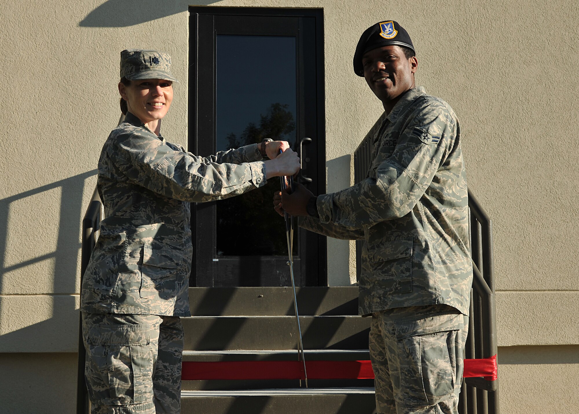 Lt. Col. Michelle Kneupper, 10th Space Warning Squadron commander, cuts the ribbon opening new dormitories with Airman 1st Class Craig Bellamy, 319th Security Forces Squadron patrolman, on Sept. 15, 2014, on Cavalier Air Force Station, N.D. The new dorm was built to provide better living conditions to security forces members who guard the AFS. (U.S. Air Force photo/Senior Airman Xavier Navarro) 
