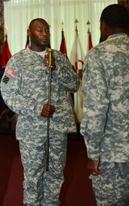 U.S. Army Sgt. Maj. James Jackson, 733rd Mission Support Group command sergeant major, accepts responsibility from outgoing command sergeant major, Sgt. Maj. Jesse Sharpe, during a change of responsibility at Fort Eustis, Va., Sept. 12, 2014. During the ceremony, the sergeants major exchanged a sword, representing the passing of responsibility and authority from an outgoing to an incoming command sergeant major. (U.S. Air Force photo by Airman 1st Class Kimberly Nagle/Released)