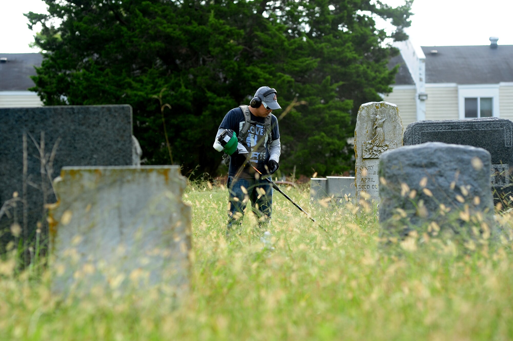 U.S. Air Force Master Sgt. Allan Araneta, 633rd Logistics Readiness Squadron customer support noncommissioned officer in charge, trims grass at the Oakland Cemetery in Hampton, Va., Sept. 13, 2014. Araneta and other volunteers lent their time to honor the veterans buried there by improving the cemetery’s appearance. (U.S. Air Force photo by Airman 1st Class Areca T. Wilson/Released) 