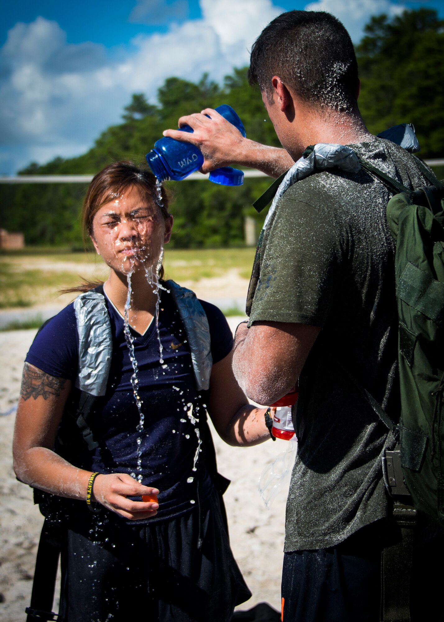Nick Camargo pours water over his wife, Lyna Camargo, to help cool her off during the GORUCK Cohesion Challenge Sept. 11, at Eglin Air Force Base, Fla.  This elite team-building event, led by a Special Forces veteran, featured military inspired challenges and missions.  Only 24 out of the original 27 completed all obstacles.  Eglin is the fifth base to complete the Team Cohesion Challenge, which is modeled after special operations training.  (U.S. Air Force photo/Tech. Sgt. Jasmin Taylor)