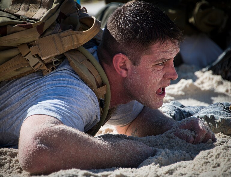 A participant low-crawls through the sand during the GORUCK Cohesion Challenge Sept. 11, at Eglin Air Force Base, Fla.  This elite team-building event, led by a Special Forces veteran, featured military inspired challenges and missions.  Only 24 out of the original 27 completed all obstacles.  Eglin is the fifth base to complete the Team Cohesion Challenge, which is modeled after special operations training.  (U.S. Air Force photo/Tech. Sgt. Jasmin Taylor)