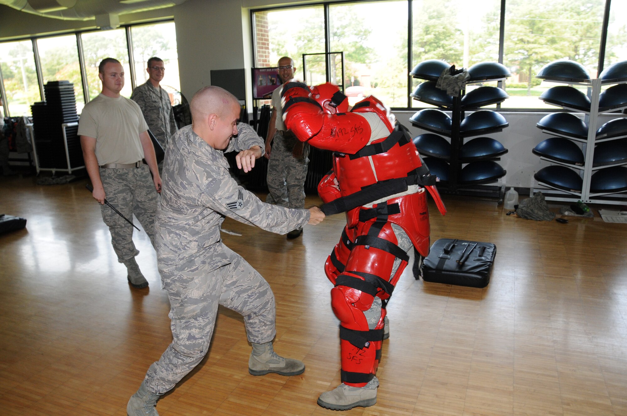 U.S. Air Force Senior Airman Ryan Haulsey (left), 192nd Fighter Wing Security Forces Instructor, and flight member Tech. Sgt. Justin Viars, perform the Red Man drill for the 192nd Security Forces Flight at Joint Base Langley-Eustis, Virginia August 10, 2014. The Red Man drill demonstrates how a security forces officer would defend and ward off an attacking aggressor. Airman 1st Class Dexter K. Hirst (left), 192nd FW Flight Member, observes the demonstration. (U.S. Air National Guard photo by Captain Craig Carper/Released)