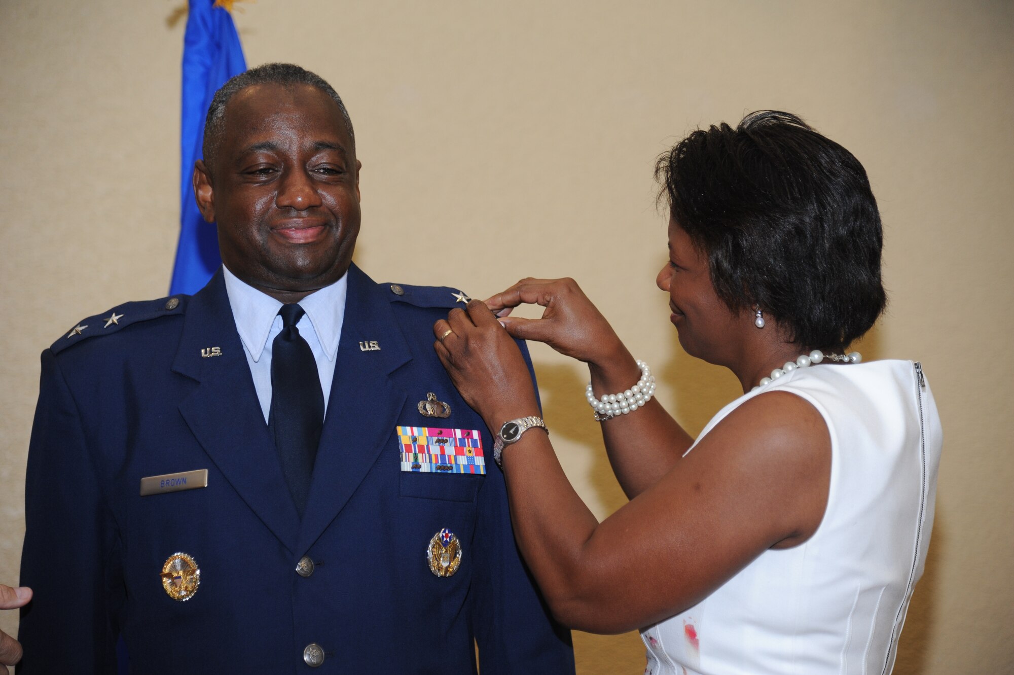 The wife of Maj. Gen. Mark Brown, 2nd Air Force commander, pins on his second star during a promotion ceremony Sept. 12, 2014, at the Bay Breeze Event Center, Keesler Air Force Base, Miss.  General Robin Rand, Air Education and Training Command commander, was the officiating officer for the event. (U.S. Air Force photo by Kemberly Groue)