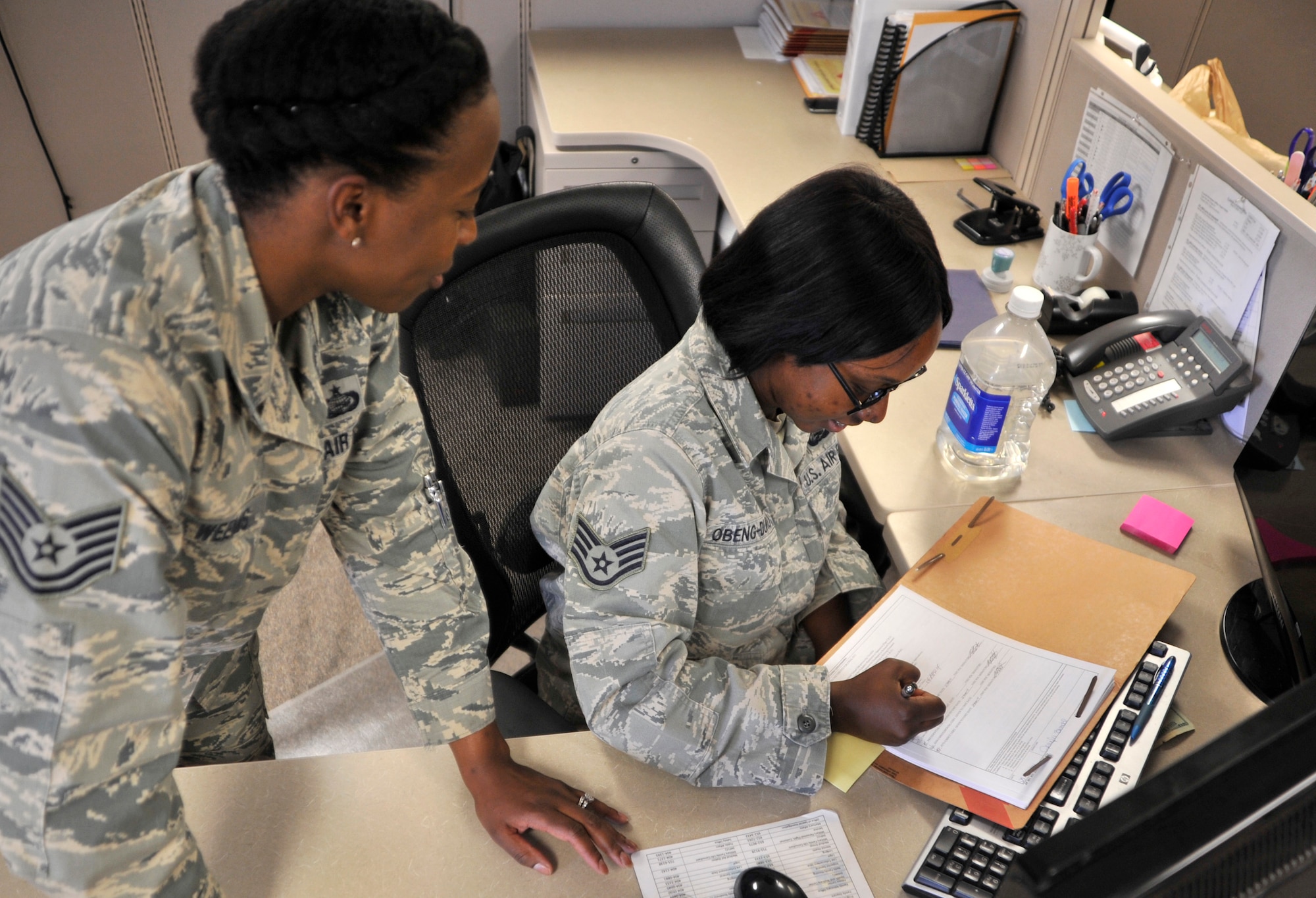 Tech. Sgt. Syreeta Weems, 799th Force Support Squadron NCO in charge of career development, left, and Staff Sgt. Jennifer Obeng-Duro, 799th FSS NCO in charge of retirements/separations, review FY14 force management packages Sept. 11, 2014, at Creech Air Force Base, Nevada. Weems and Obeng-Duro were coined by Col. James Cluff, 432nd Wing/432nd Air Expeditionary Wing commander, for their ability to process 266 individuals through Quality Force Retention Boards and Enlisted Retention Boards in the most efficient and timely way, on top of their normal duties during the FY14 force management programs’ implementation. (U.S. Air Force photo by Airman 1st Class Christian Clausen/Released)