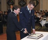 Maj. Kelli Green, 341st Security Forces Squadron commander, and Airman 1st Class William Clark, 341st Contracting Squadron contracting apprentice, ceremonially cut a cake at the 2014 Air Force Ball Sept. 13 at the Grizzly Bend. Tradition requires the longest-serving commissioned officer in attendance to pair with the enlisted member having the least time in service, and make the first cut in unison. (U.S. Air Force photo/Airman 1st Class Joshua Smoot)