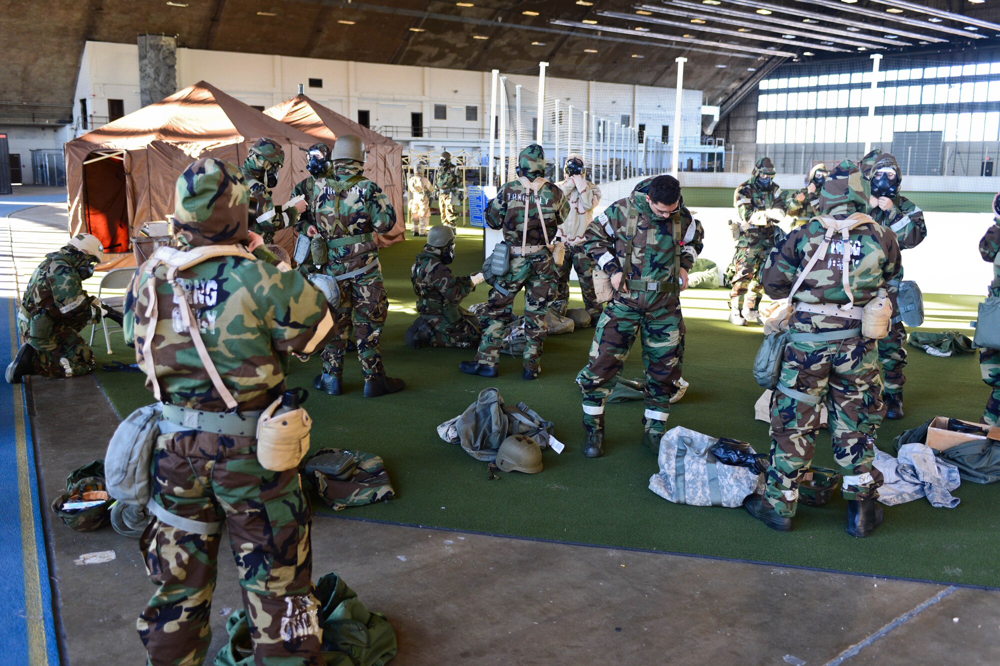 Airmen put on mission-oriented protective posture gear for contamination control area training during an operational readiness exercise at Ellsworth Air Force Base, S.D., Sept. 12, 2014. The purpose of the CCA was to train Airmen on how to properly remove contaminated individual protective equipment after a chemical or biological attack. (U.S. Air Force photo by Senior Airman Zachary Hada/Released)