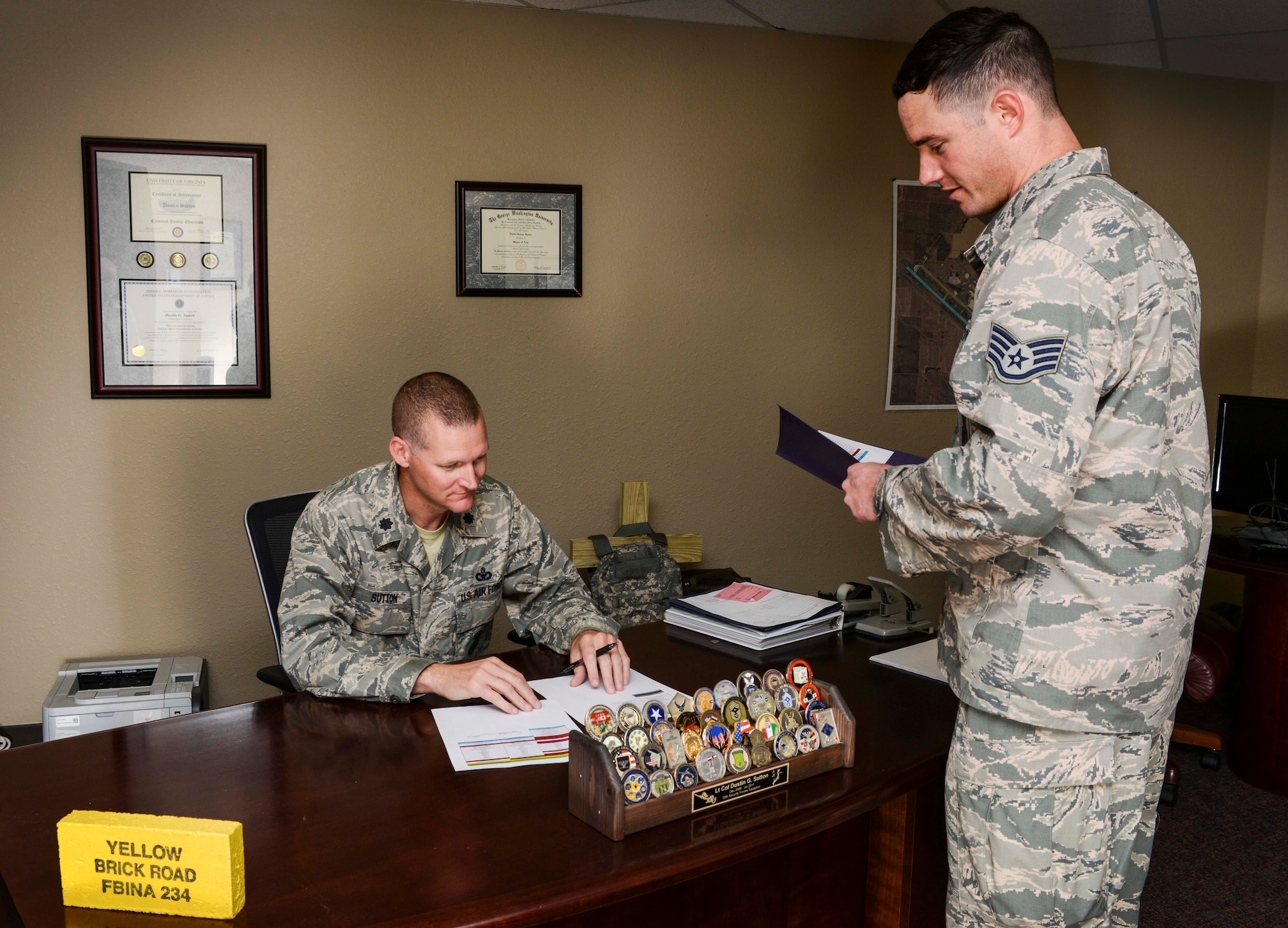 Staff Sgt. Colin Vessels, 5th Security Forces Squadron alternate personnel reliability program manager, meets with Lt. Col. Dustin Sutton, 5th SFS commander, regarding an Airman’s records on Minot Air Force Base, N.D., Aug. 5, 2014. Vessels regularly updates the commander on the PRP status of approximately 525 Airmen in the 5th SFS. (U.S. Air Force photo/Senior Airman Stephanie Morris)