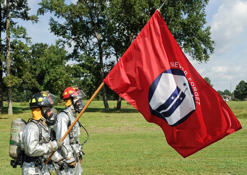 Senior Airman Christopher Parker (left) parker and Tech. Sgt. Jeremy Luedtke, both of the 4th Civil Engineer Squadron fire department, with the 9/11 memorial flag during the 9/11 Remembrance Run at Seymour Johnson Air Force Base, North Carolina, Sept. 11. Members of Team Seymour ran continuously with the 9/11 memorial flag for 24 hours. The run began at 9 a.m. when the fire department’s youngest firefighter left the firehouse carrying the flag and ended when the oldest, Sean Quinby, 4th CES fire chief, returned it 24 hours later. Participants racked up a combined total of 1,397 miles ran. (U.S. Air Force photo/Airman 1st Class Aaron Jenne) 
